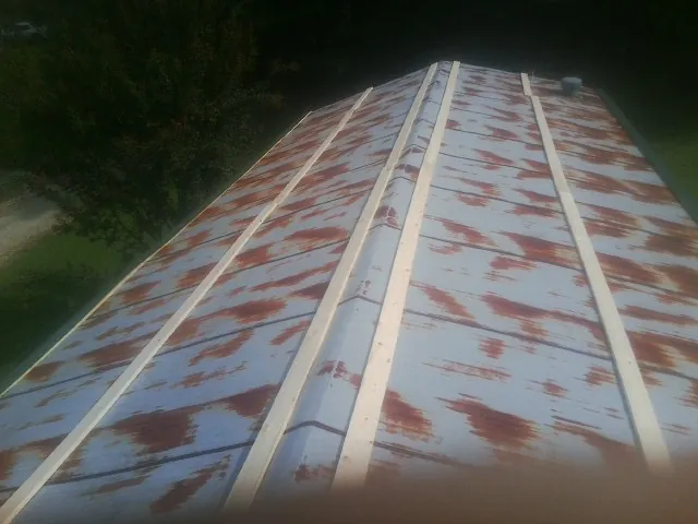 Rusted metal roof panels with new wood purlins before replacement — Storm Damage Roof Repair in Quinlan by Roofing Brothers
